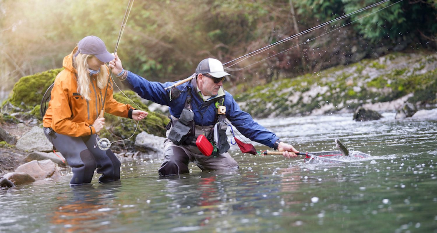 young woman learning to fly fishing with a guide